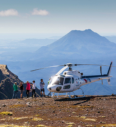 Dreamaroo Luxury, Helicopter & Fly-in Safaris New Zealand, Five People Standing By A Helicopter Parked on Mountain With Mountain View Image