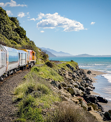 Dreamaroo Luxury, Expeditions Luxury Trains New Zealand, Train Running Alongside Mountain and Beach View