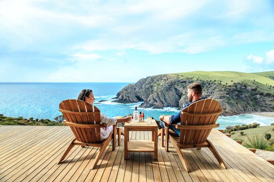 Dreamaroo Luxury, Kangaroo Island, Man and Woman Couple Drinking, Seated on Wooden Chairs, View of Ocean Image